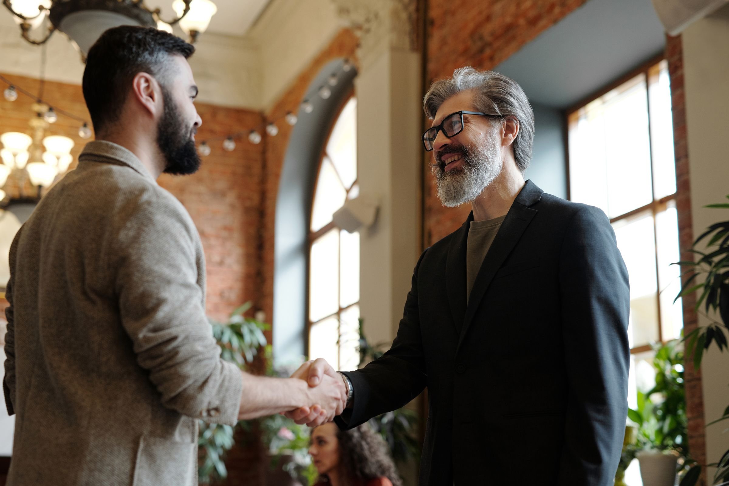 Two people shaking hands in an office after agreeing a deal