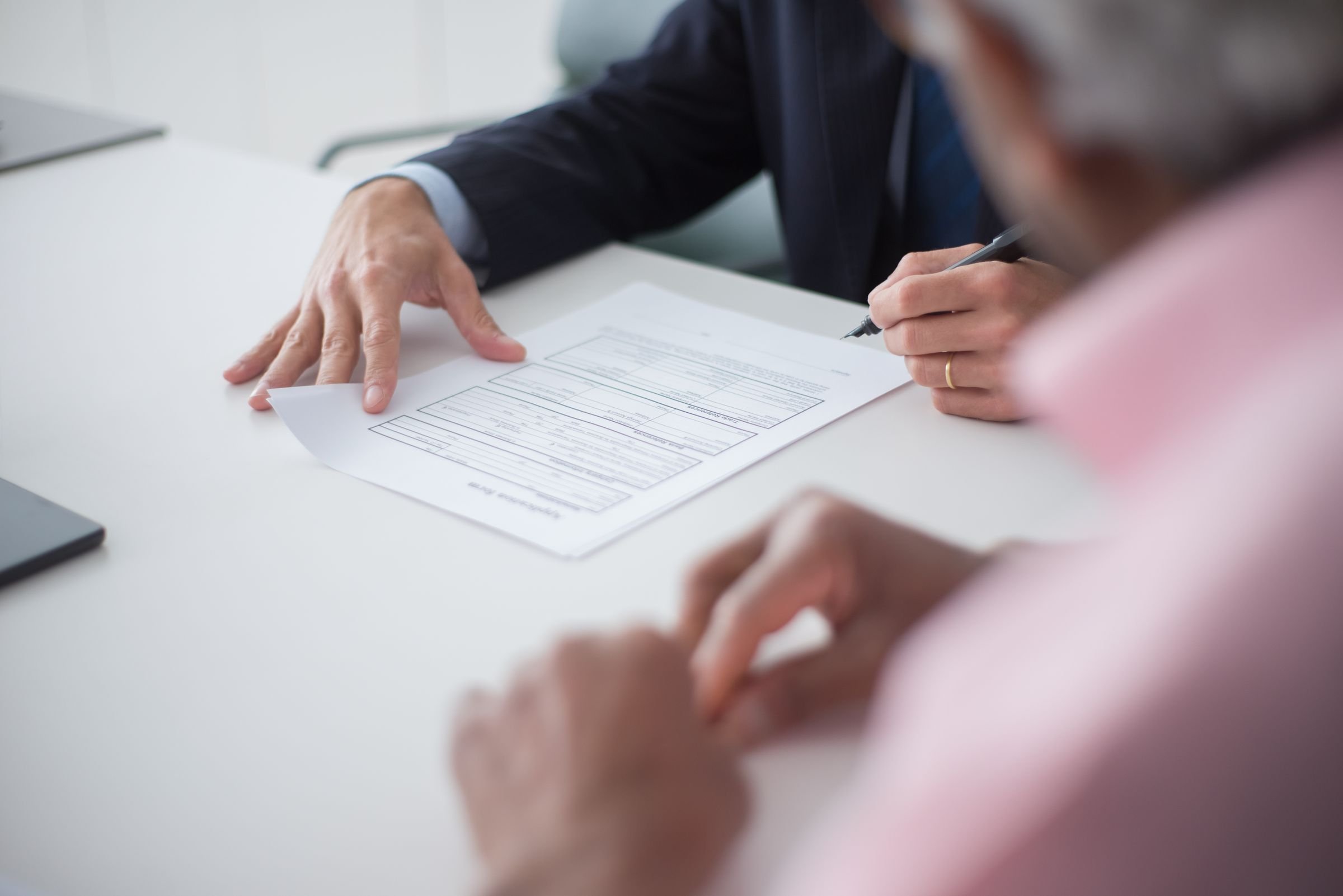 Two professionals going through a document together across a desk