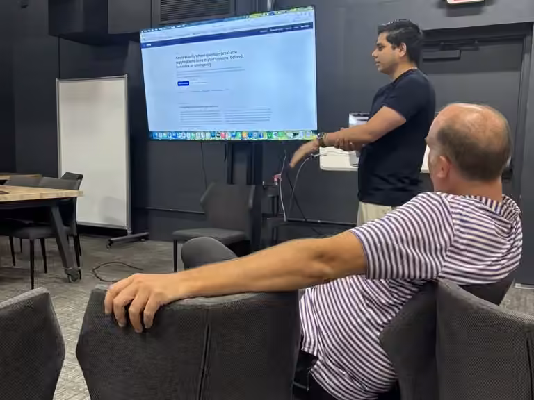 Members watch a builder demo his product on the wall screen at Hygge Coworking