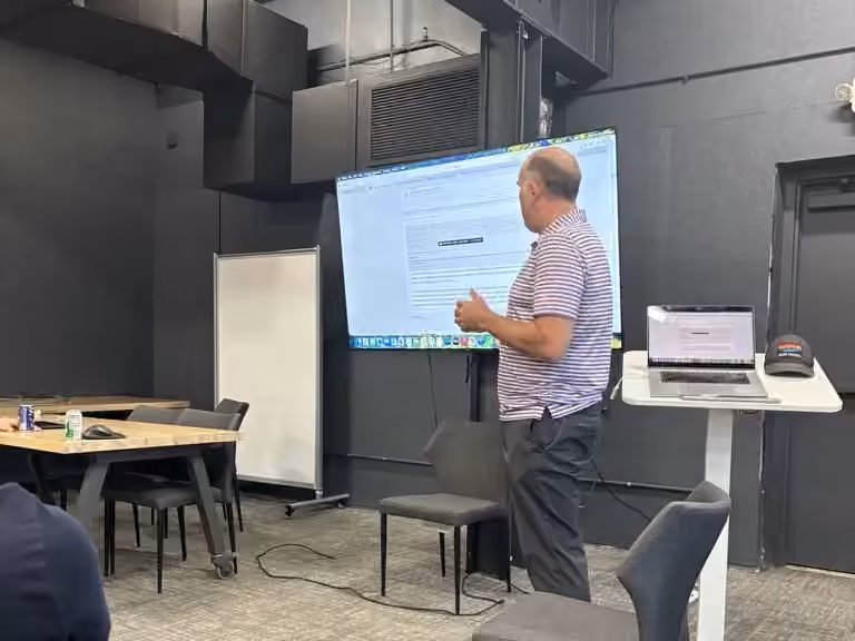 A presenter in a striped shirt talks through his screen at the first Building with AI Charlotte meetup